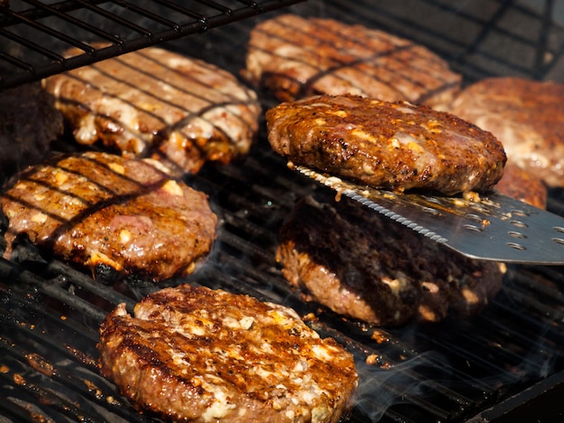 Hamburger dla smakoszy paruje na grillu.