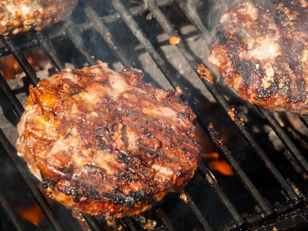 Hamburger dla smakoszy paruje na grillu.