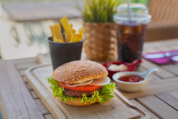 Hamburger i frytki. Świeży, smaczny burger z frytkami na drewnianym stole