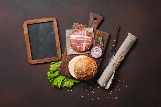 Hamburger składniki surowy kotlet sałata kok ogórki i cebula na zardzewiałym tle