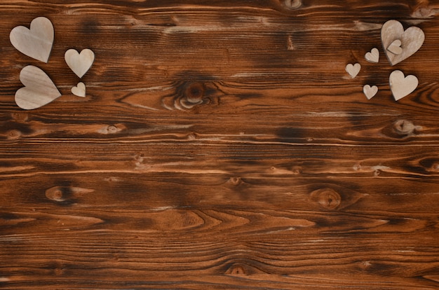 Handmade drewniani serca na textured drewnianym tle.