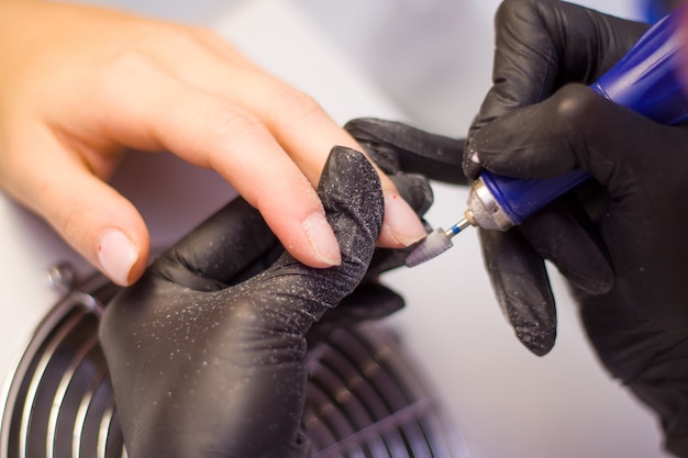 Hands Of Manicurist W Czarnych Rękawiczkach I Nails Of Client. Kobieta W Salonie Piękności.