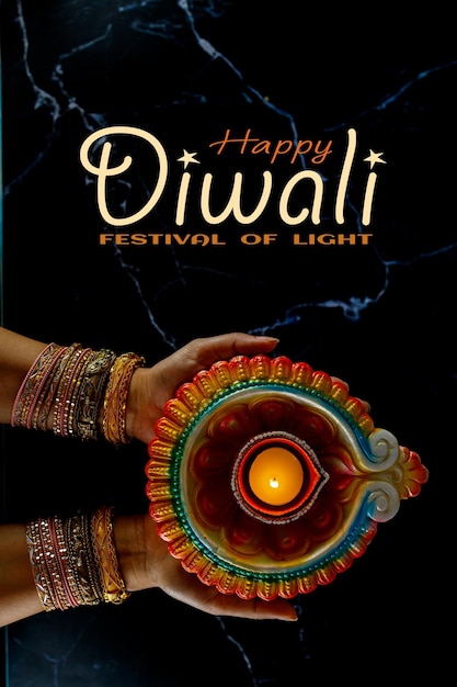 Zdjęcie happy diwali - kobieta ręce z henną trzymając zapaloną świeczkę na białym tle na ciemnym tle. lampy clay diya zapalone podczas dipavali, hinduskiego festiwalu świateł. skopiuj miejsce na tekst.