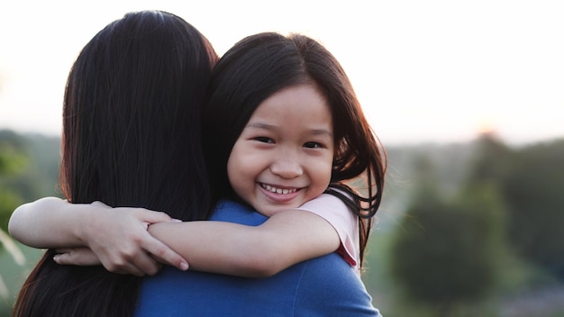 Zdjęcie happy family concept zbliżenie portret szczęśliwy azjatyckie dziecko dziewczynka uścisk lub przytulanie matki