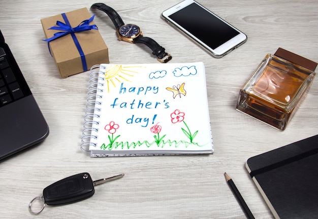 Zdjęcie happy fathers day napis z notebookiem laptopa i filiżanką kawy na drewnianym tle