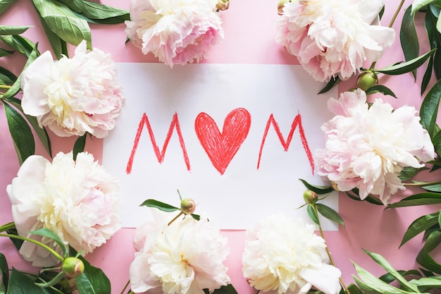 Zdjęcie happy mothers day świeże piwonie i pocztówka dla mamy na różowym tle stylowa kartka z życzeniami szablon karty z pozdrowieniami z tekstem