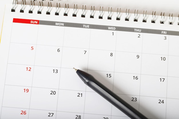 harmonogram miesiąca kalendarzowego, aby umówić się na spotkanie lub zarządzać harmonogramem każdego dnia, leżał i długopis na żółtym tle w celu planowania koncepcji pracy i podróży