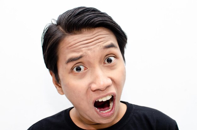 Headshot azjatyckiego mężczyzny z gniewnym, szalonym, depresyjnym i wściekłym wyrazem twarzy izolowanym na białym