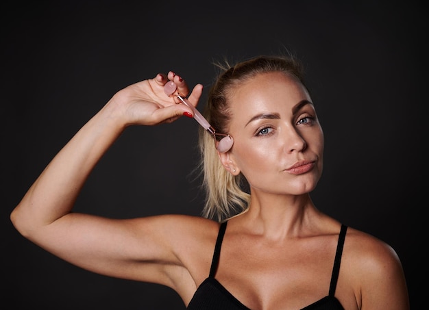 Headshot ładna kobieta robi drenaż limfatyczny twarzy masażerem rolkowym Zabieg Beauty Spa