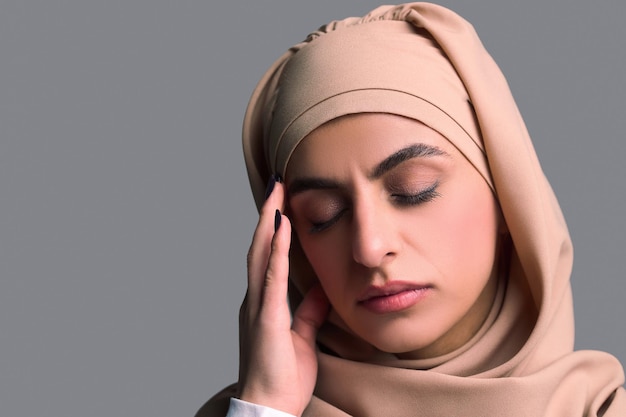 Zdjęcie headshot młodej kobiety w beżowym hidżabie