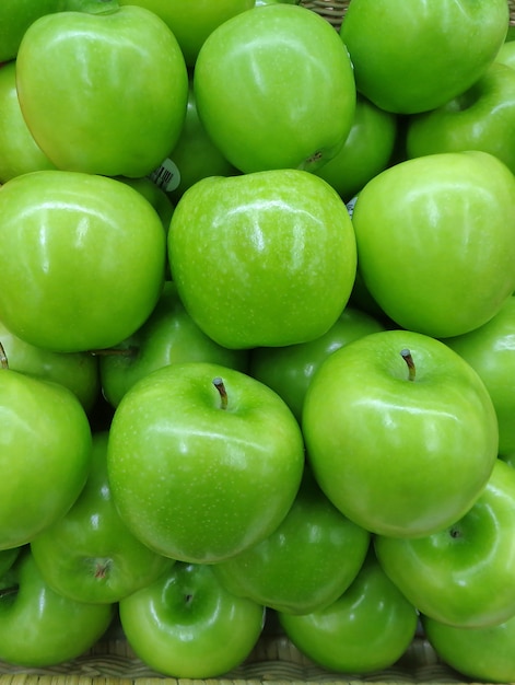 Heap of Vivid Green Apples, pionowe zdjęcie w tle