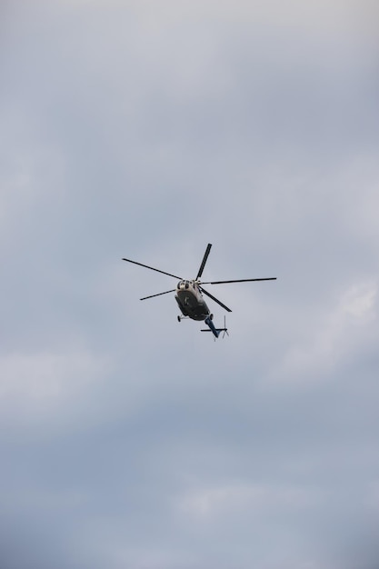 Helikopter lecący na szarym, zachmurzonym niebie