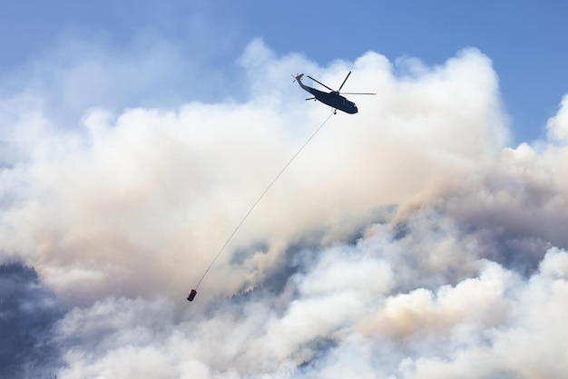 Helikopter Wildfire Service lecący nad BC Forest Fire and Smoke na górze w pobliżu Hope