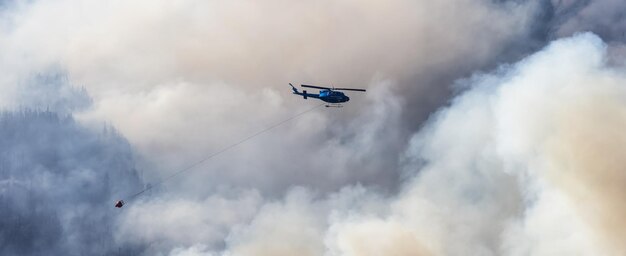 Helikopter Wildfire Service lecący nad BC Forest Fire and Smoke na górze w pobliżu Hope