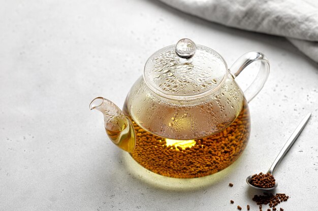 Herbata gryczana i granulki Herbata w szklanym przezroczystym czajniczku Superfood Tajwan Ku Qiao Szare tło