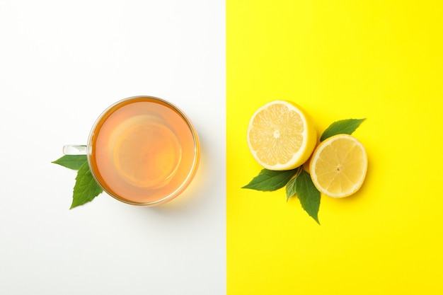 Herbata i cytryna na dwukolorowej powierzchni. Dojrzały owoc