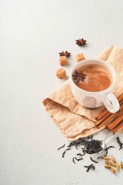 Herbata Masala Przyprawiona herbata Masala chai z mlekiem i przyprawami na jasnoszarym tle Tradycyjny indyjski napój Spice drink Copy space Selektywny fokus