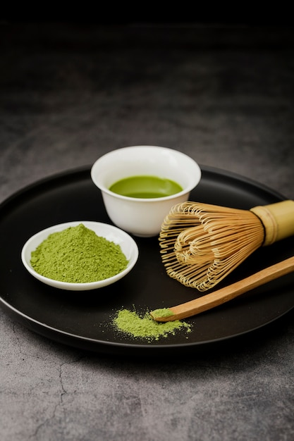 Zdjęcie herbata matcha na talerzu z bambusową trzepaczką