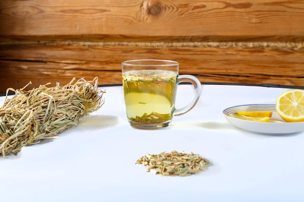 Zdjęcie herbata z trawy cytrynowej w filiżance obok cytryny i słodyczy na serwetce na stole