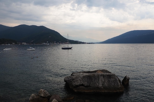 Herceg Novi Czarnogóra Urlop na plaży morskiej Wycieczki morskie Łodzie pływające po Morzu Adriatyckim Śródziemnomorski biznes turystyczny Żaglówki i góry Małe zmarszczki na słonej wodzie Odbicie nieba w falach