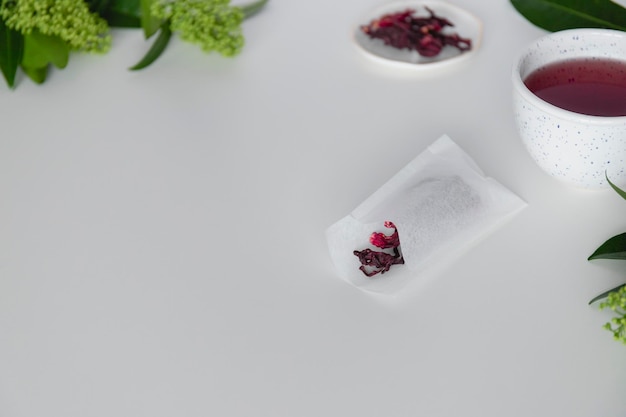 Hibiskusowe torebki herbaty z suchymi liśćmi hibiskusa na białym tle