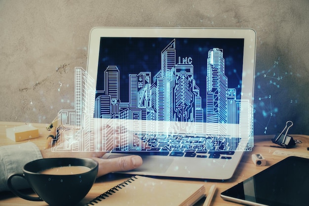 High-tech rysunek miasta z biznesmenem pracującym na komputerze na tle Smartcity koncepcja podwójna ekspozycja