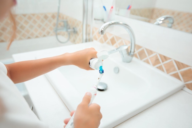 Zdjęcie higienę zębów szczęśliwa mała blondynka myjąca zęby zdrowa koncepcja