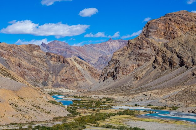 Himalajski krajobraz górski wzdłuż autostrady Leh do Manali w Indiach. Niebieska rzeka i majestatyczne góry skaliste w indyjskich Himalajach, regionie Ladakh, Dżammu i Kaszmir, Indie. Koncepcja przyrody i podróży