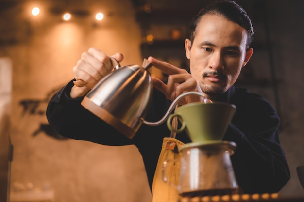 Hipster barista nalewający gorącą wodę do robienia kawy z kroplówką lub filtrem w kawiarni powolny napar na kofeinę napój aromatyczny napój w filiżance świeża czarna kawa i espresso na śniadanie