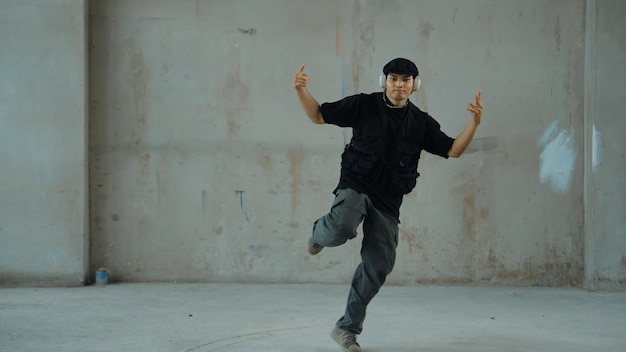 Zdjęcie hipster ćwiczący breakdance podczas słuchania muzyki z słuchawek endeavor