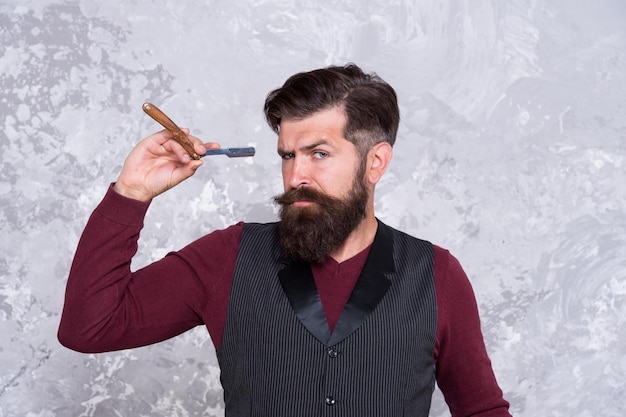 Hipster golenie twarzy ostrzem pewny siebie mężczyzna broda brutalny fryzjer mistrz brodaty fryzjer gotowy do golenia codziennego gomming higiena osobista i sprzęt fryzjerski retro sprzęt i narzędzia