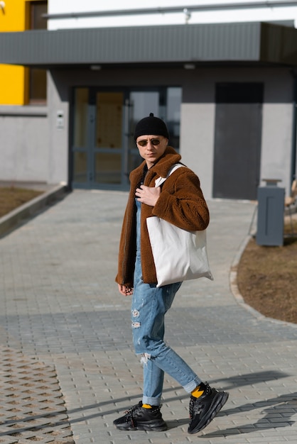 Hipster idzie do sklepu z torbą wielokrotnego użytku