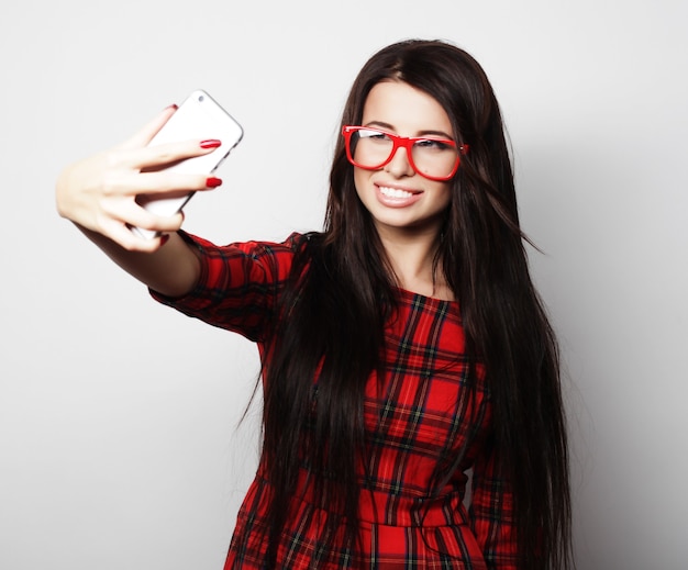 Hipster ładna dziewczyna biorąc selfie. Młoda i szczęśliwa.