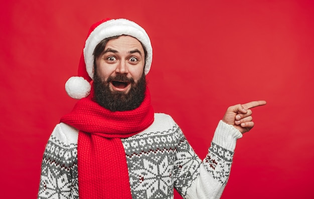 hipster w Santa hat wskazując na bok