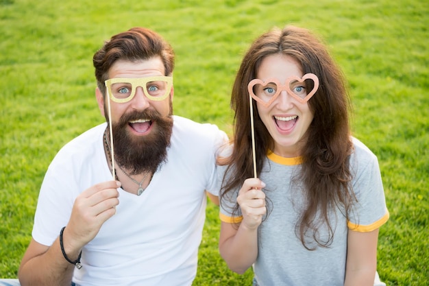 Historia miłosna. Para relaksujący zielony trawnik. Hipster brodaty mężczyzna i ładna kobieta w miłości. Letnie wakacje. Emocjonalna para promieniująca szczęściem. Szczęśliwi razem. Para zakochanych wesołych rekwizytów stoiska młodzieży.