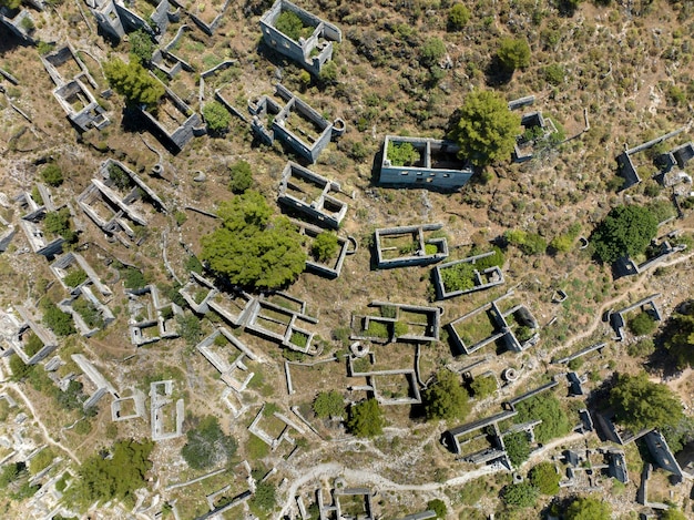 Historyczna lycka wioska Kayakoy, Fethiye, Mugla, Turcja. Zdjęcie lotnicze z drona z góry miasta duchów Kayakoy. Wioska grecka. Wieczorne wściekłe ciepłe słońce starożytnego miasta kamienia