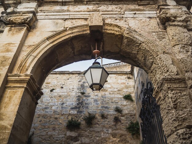 Zdjęcie historyczny kamienny łuk triumfalny wejścia do zamku z starożytną lampą