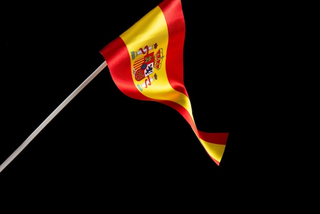 Hiszpańska flaga na czarnym tle rozwija się i trzepocze na wietrze z bliska macha flagą