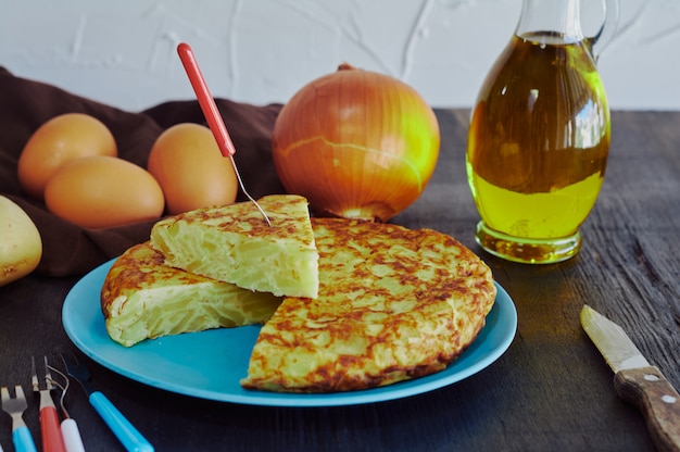 Hiszpański omlet z ziemniakami, jajkiem i cebulą, w towarzystwie oliwy z oliwek