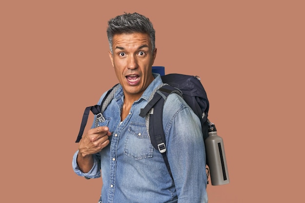 Hiszpański turysta z plecakiem i butelką wskazującą na bok