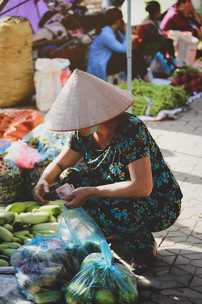 Hoi An, Wietnam - 7 lipca 2019: Wietnamczycy kupują warzywa na porannym targu w Hoi An, Wietnam