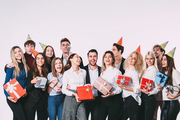 Zdjęcie holidays concept grupa ludzi z kolegami z prezentami w rękach zabawy i uśmiechu