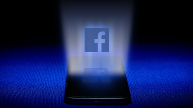 Zdjęcie hologram z logo facebooka. hologram facebook logo obraz na niebieskim tle.