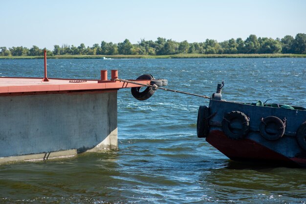 Holownik ciągnie pływający betonowy ponton w zbliżeniu