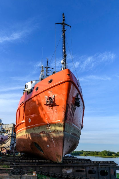 Zdjęcie holownik na lądzie w stoczni remontowej statków