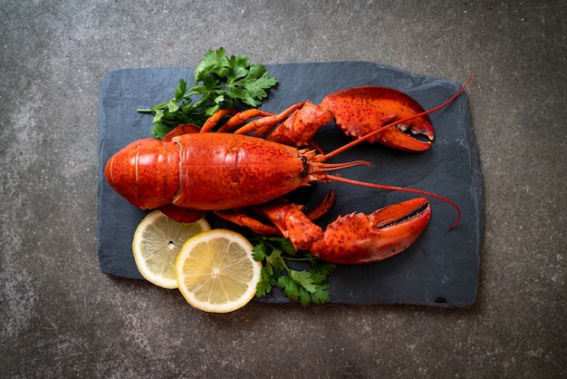 homar z warzywami i cytryną na czarnej tablicy łupków