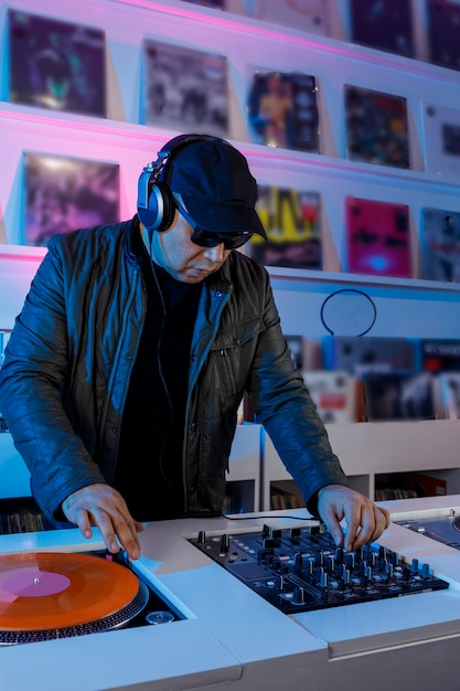 Hombre Dj Mezclando Musica En Un Tornamesa Con Discos De Vinil Y Escuchando En Los Audifonos