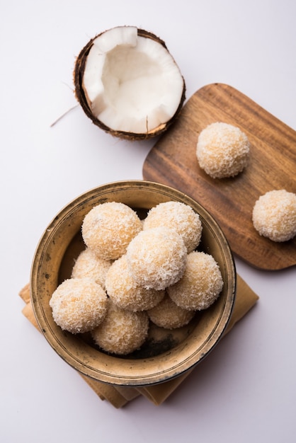 Homemade Coconut Sweet Laddoo LUB Nariyal Laddu z mlekiem skondensowanym i cukrem, popularne jedzenie festiwalowe. Podawane na nastrojowym tle, selektywne skupienie