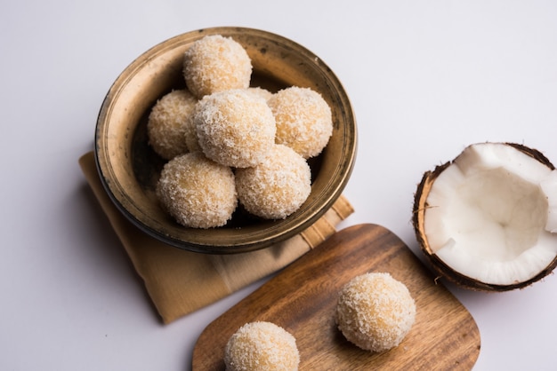 Homemade Coconut Sweet Laddoo LUB Nariyal Laddu z mlekiem skondensowanym i cukrem, popularne jedzenie festiwalowe. Podawane na nastrojowym tle, selektywne skupienie