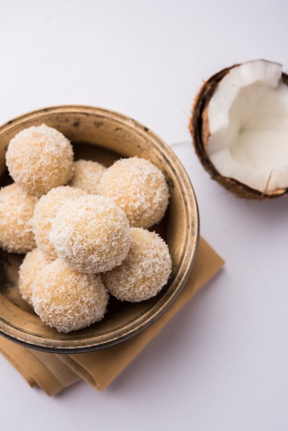 Homemade Coconut Sweet Laddoo LUB Nariyal Laddu z mlekiem skondensowanym i cukrem, popularne jedzenie festiwalowe. Podawane na nastrojowym tle, selektywne skupienie